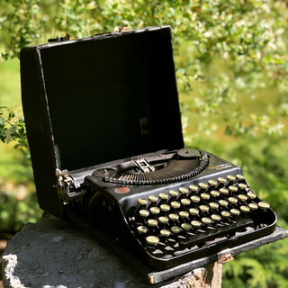 Small portable black vintage Remington typewriter with case and round keys.