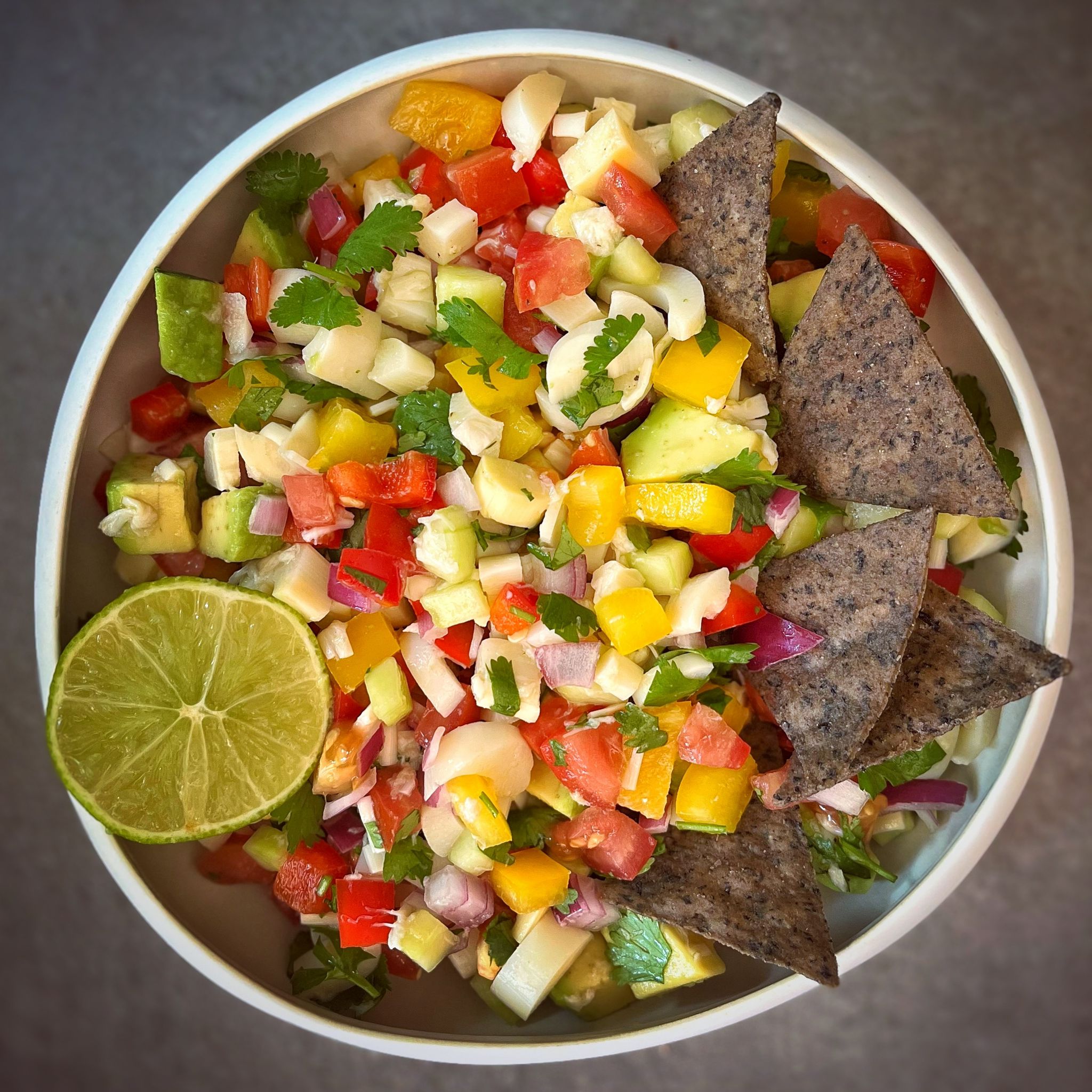 Fresh vegan hearts of palm ceviche with avocado, peppers, tomato, and cilantro