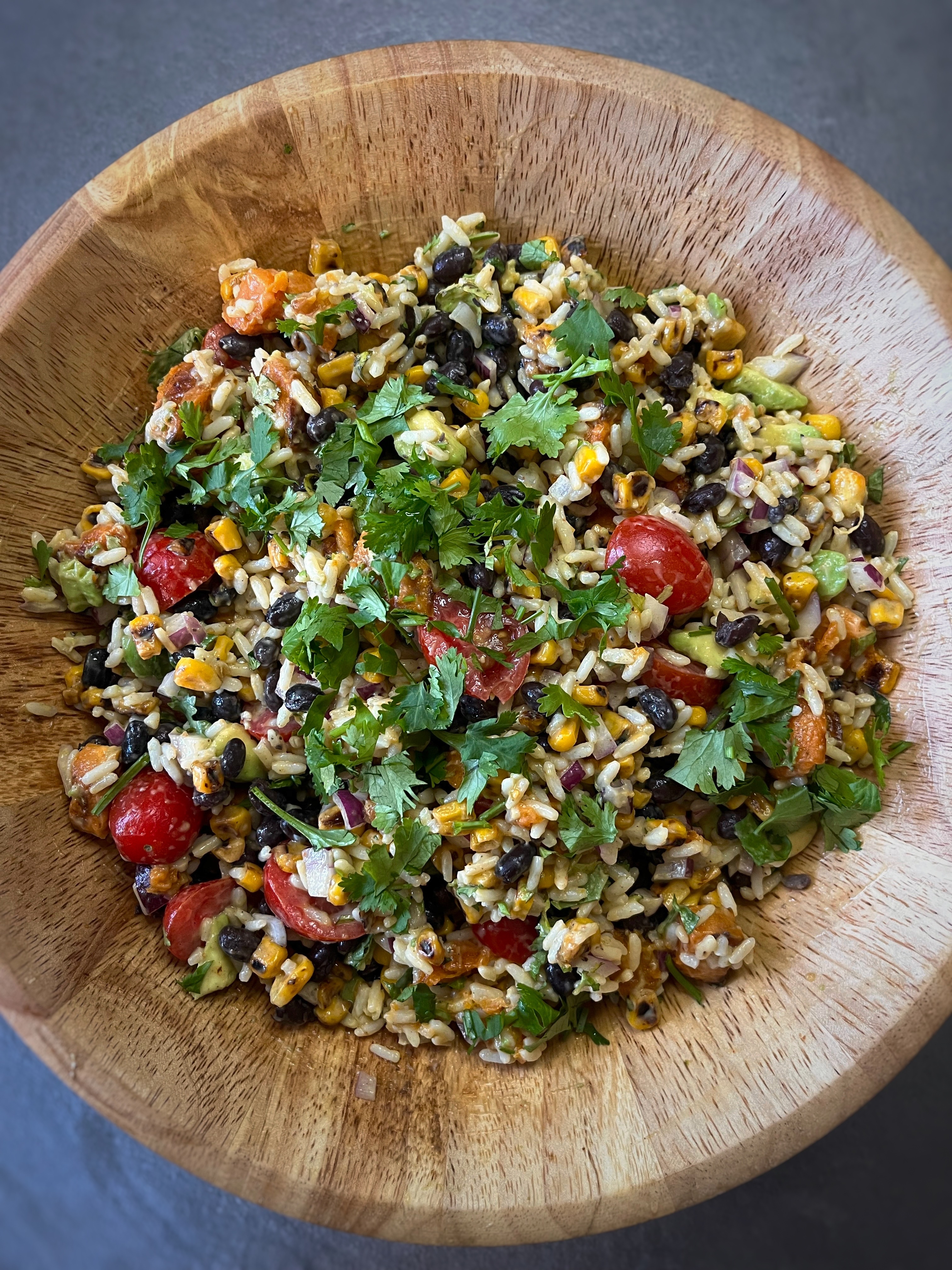 Vegan naked burrito bowl with rice, sweet potato, black beans, corn, avocado, and chipotle dressing
