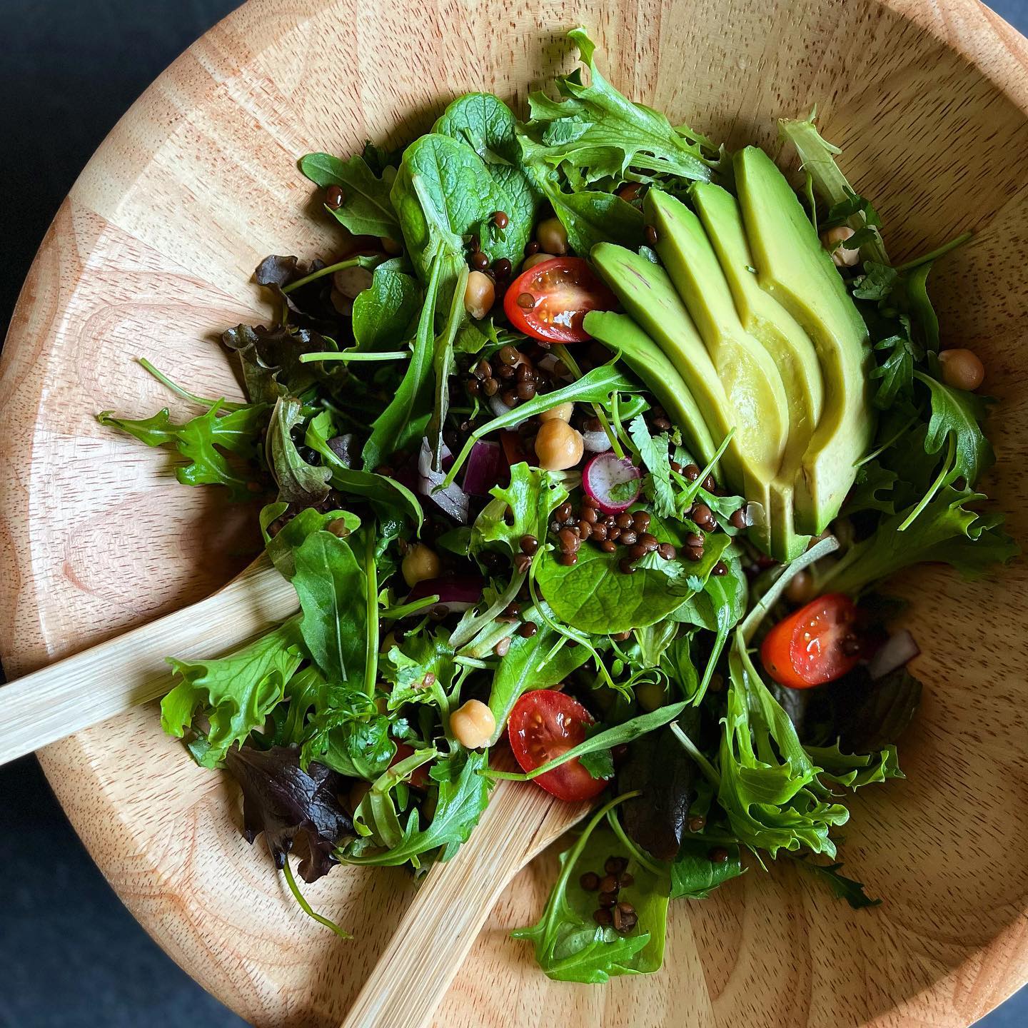 Black lentil salad with avocado, chickpeas, tomatoes, radishes, and fresh greens