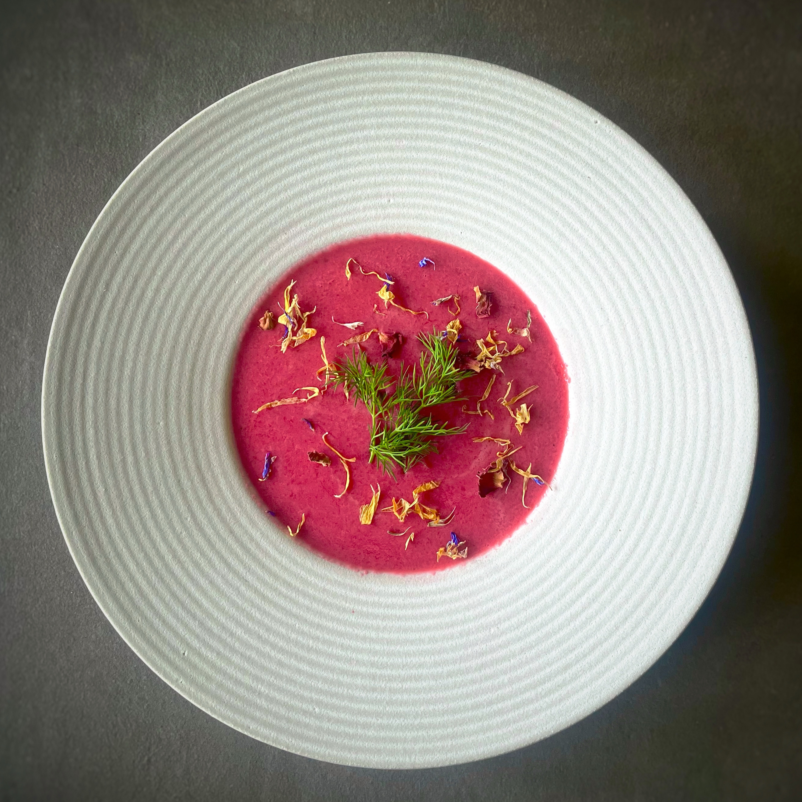 Vibrant chilled vegan beetroot soup garnished with fresh dill