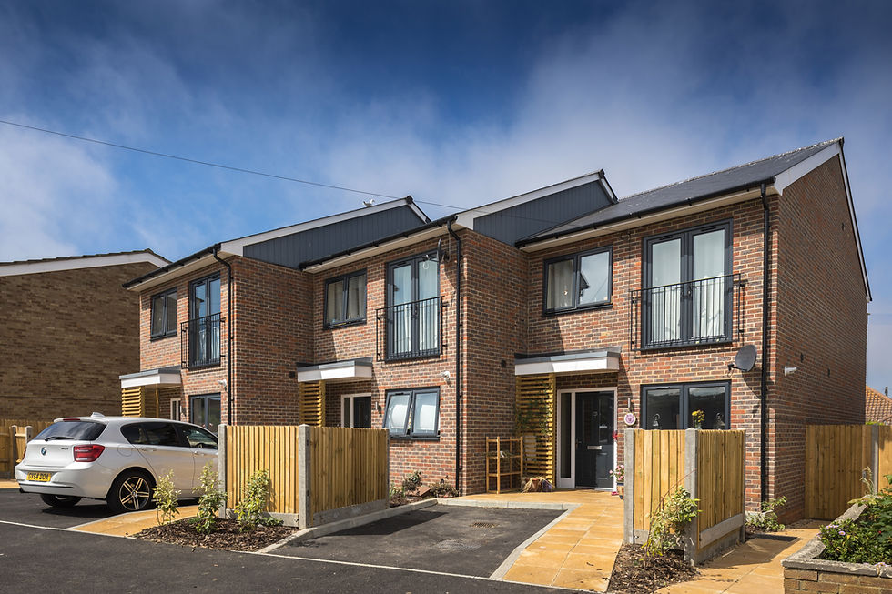 External photograph of the Headland Way houses from the street showing the brick and Cedral cladding external finish and the natural timber highlights.