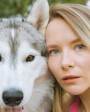 Beautiful woman owner petting a husky dog wearing a stylish BC Style & Crafts collar.