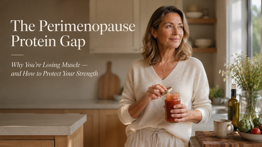 Woman in her late 40s holding a glass jar in a bright kitchen, illustrating how proper protein intake helps protect muscle strength during perimenopause.
