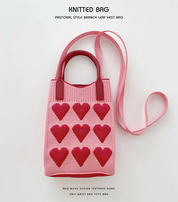 Love Knit Shoulder Bag in Pink. Adorable and stylish shoulder bag featuring a trendy knit design with a heart motif. Perfect for adding a touch of love to your look. 