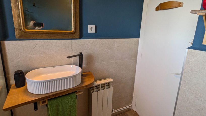 Cuarto de baño en la Posada de la Luz (Torralba de Ribota - Zaragoza),  coliving rural, coworking y talleres compartidos,  donde se ve una lavabo, un radiador y  un espejo
