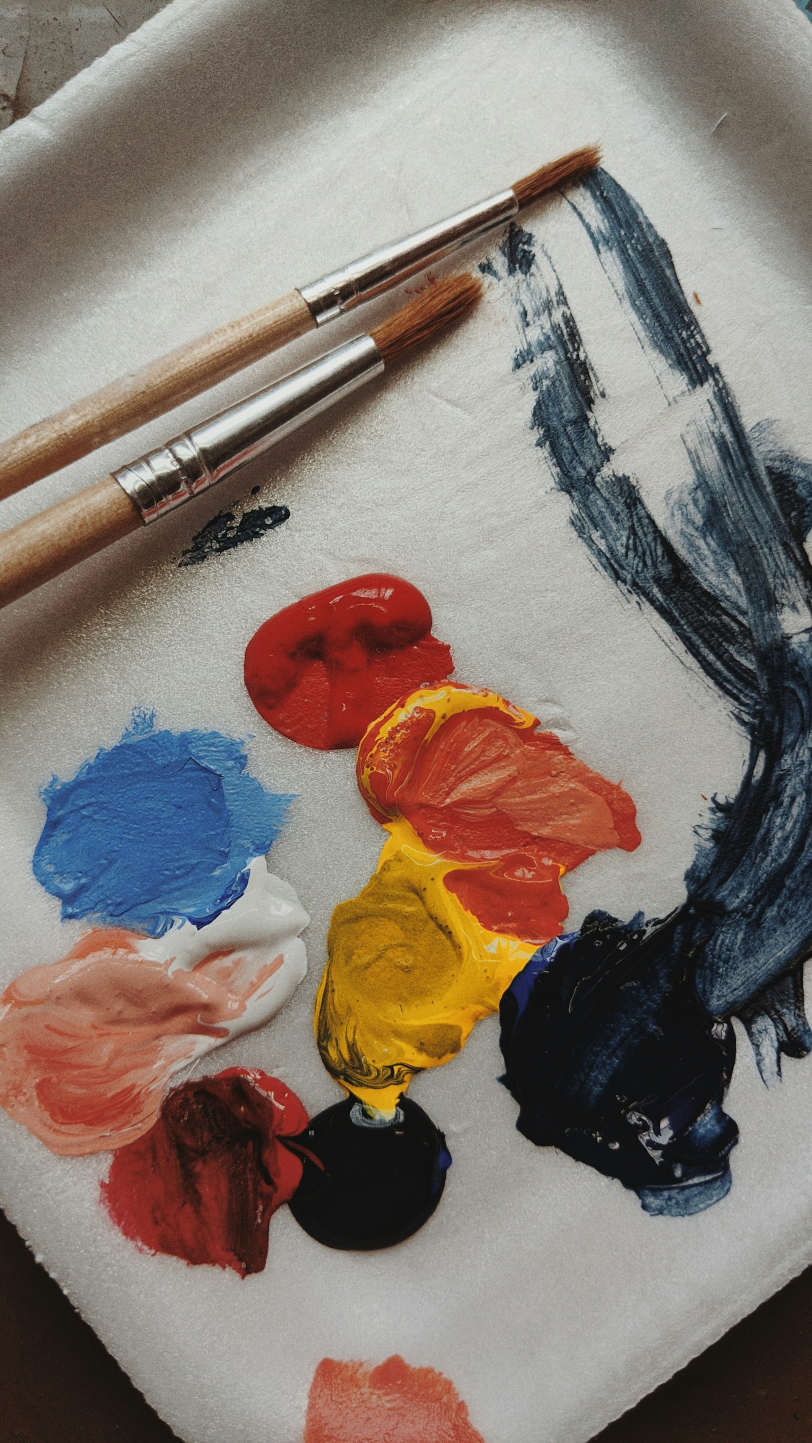 Paleta com tintas acrílicas coloridas e pincéis