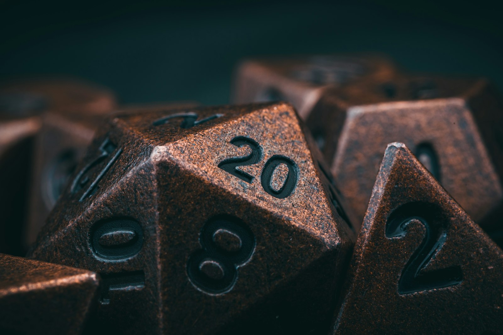 Dados de metal de RPG com o número 20 em destaque