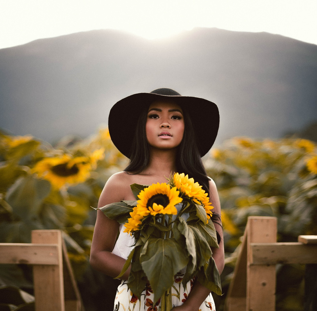 beautiful woman with long dark hair in a field of flowers.