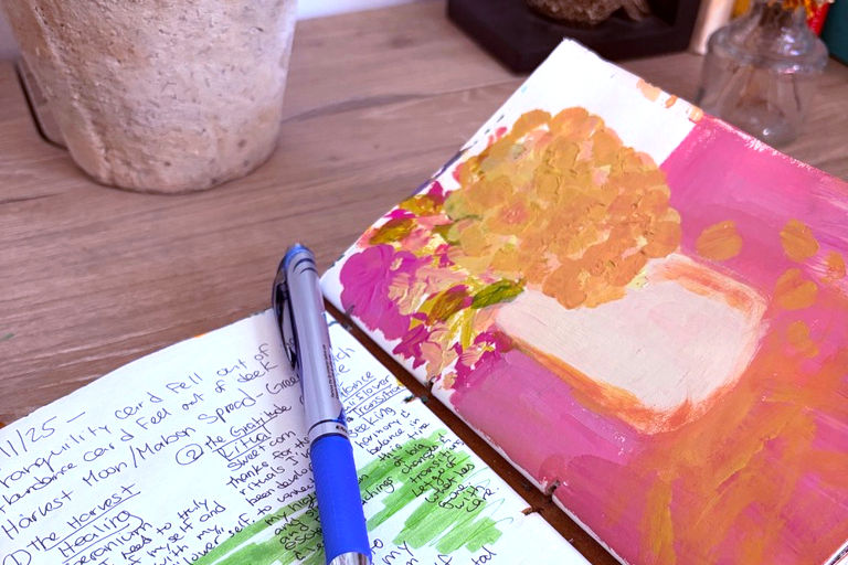 Eye-level view of an open art journal with colorful drawings and writing