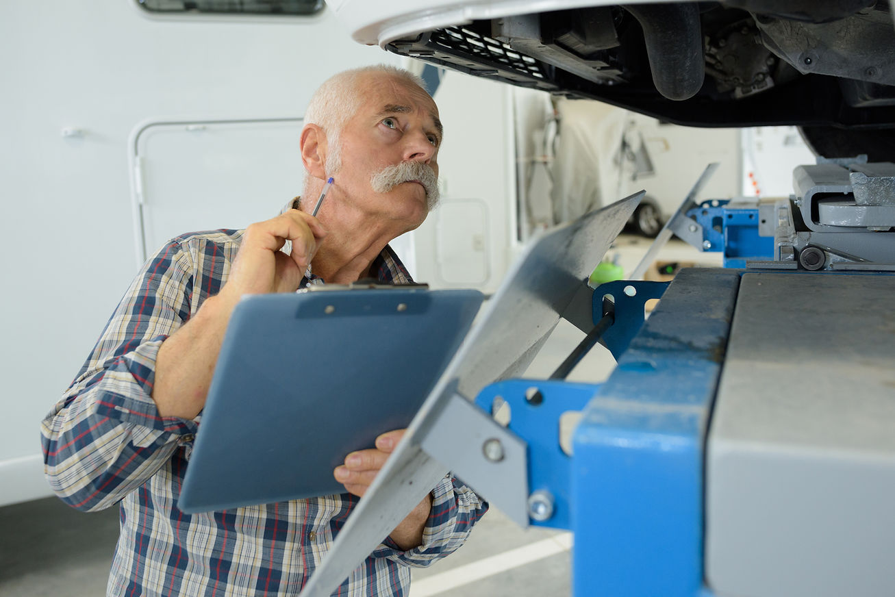 senior man while repairing caravan.jpg