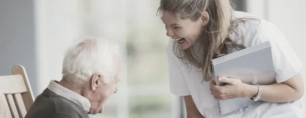 in-home caregiver laughing with senior client