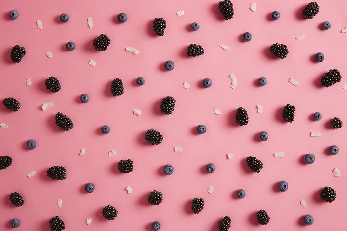 overhead-shot-of-juicy-blueberry-and-blackberry-coconut-flakes-on-rosy-background-summer-t