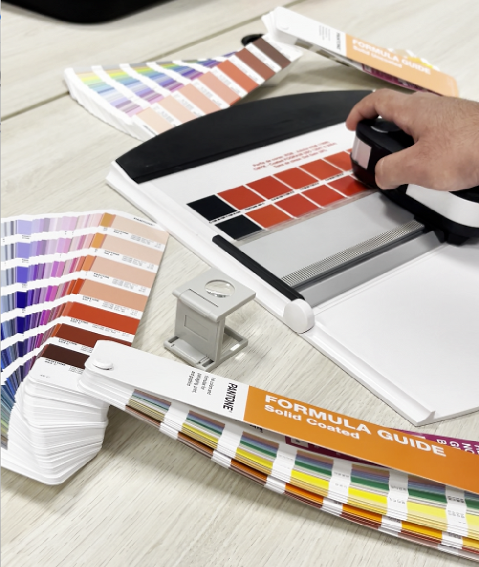 Guias Pantone e amostras de cor sobre mesa técnica para especificação de adesivos industriais