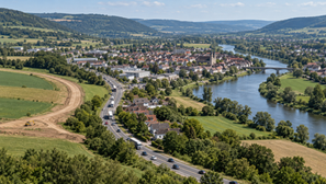 Luftaufnahme einer Stadt an der Weser mit Durchgangsverkehr und geplanter Ortsumgehung
