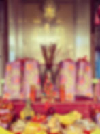 Altar with fruits, offerings, and golden deity, representing a Five Direction Wealth Talisman