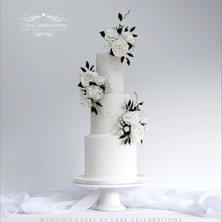 3 Tier white wedding cake with a trio of sugar floral arrangements