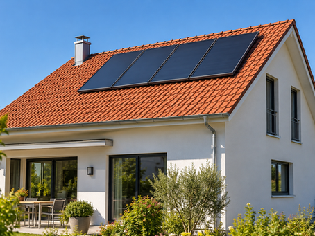 Solarthermie Förderung: Einfamilienhaus mit Flachkollektoren einer Solarthermieanlage auf dem Süddach bei Sonnenschein