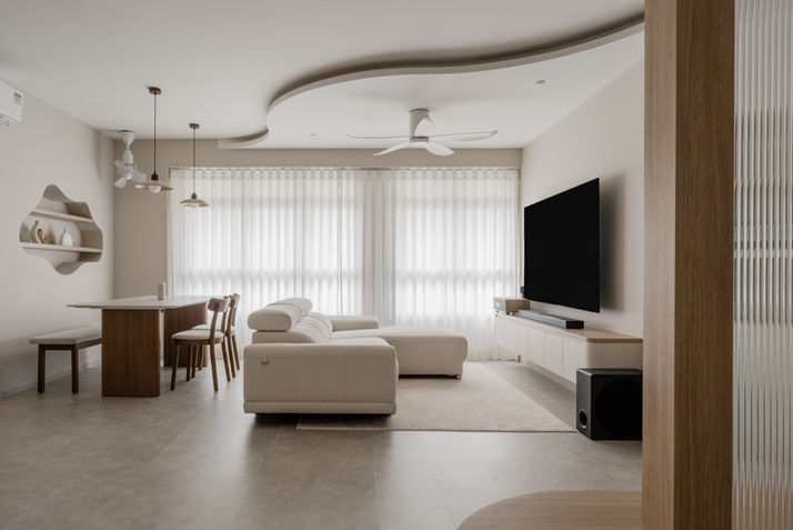 Multidisciplinary living room design showcasing fluid spatial flow and custom curved carpentry by Parallax Studio Singapore.