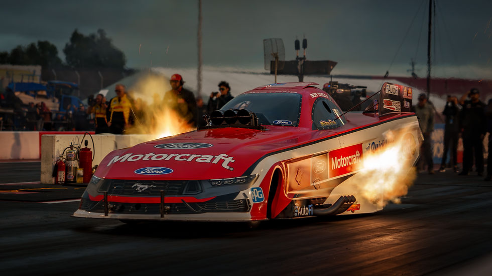 the Motorcraft Quick Lane nitro Mustang Dark Horse funny car exploding off the starting line in Sonoma California at night with flames shooting from the headers
