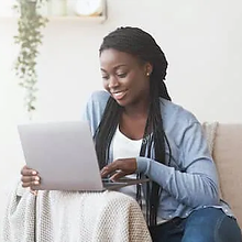 Stock-Young-Black-Woman-Working-With-Laptop-On-Sofa-AdobeStock305462423 copy.webp