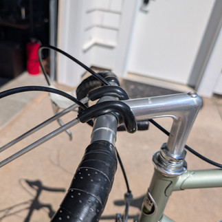 Center loop seated on the bike stem with arms over the handlebars