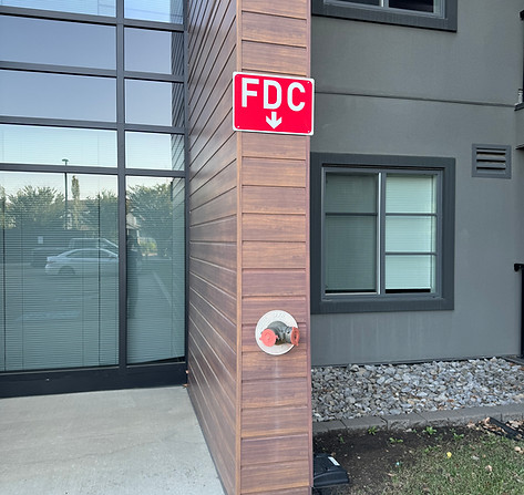 Fire Department Connection (FDC) on building exterior during inspection.