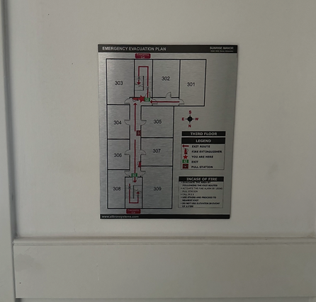 Wall-mounted emergency evacuation map showing floor layout and exit routes.