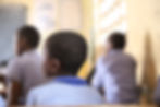 Children seated in a classroom, viewed from behind during a lesson