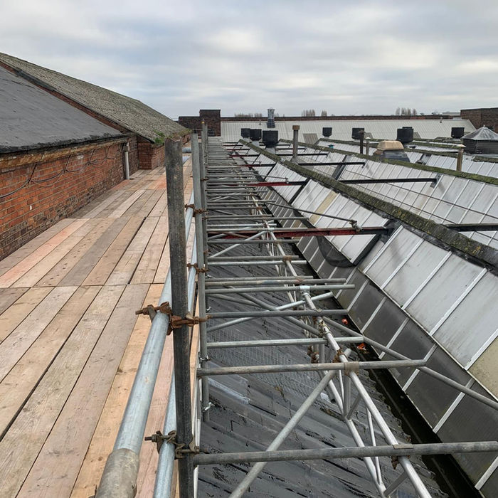 High-level scaffold platform built directly on roof surface for structural repairs and roof replacement