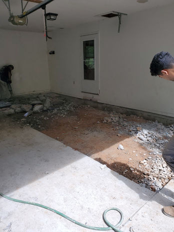 Garage concrete floor removed, exposing dirt and debris