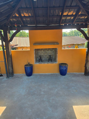Outdoor fireplace on orange wall, blue planters, concrete