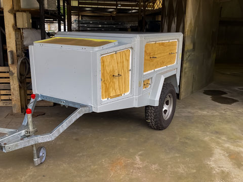 Trailer body being sanded and prepped thoroughly before paint application.