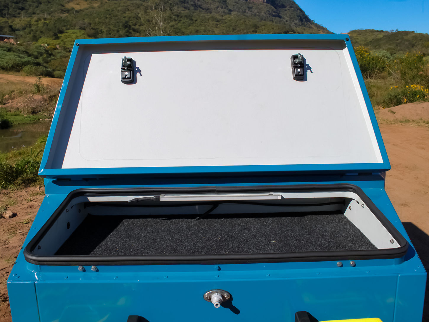 Lockable nose cone with shallow top-access storage space above utility area.