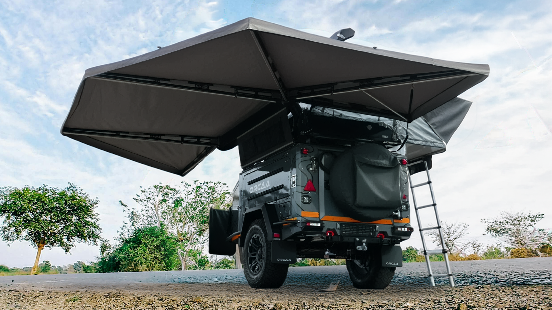 Side view of an off-road trailer featuring the free-standing ORCAA 270° Awning, showcasing its heavy-duty aluminum arms and 300 gsm ripstop canvas.