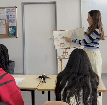 Une intervenante présente un livre illustré à des collégiens