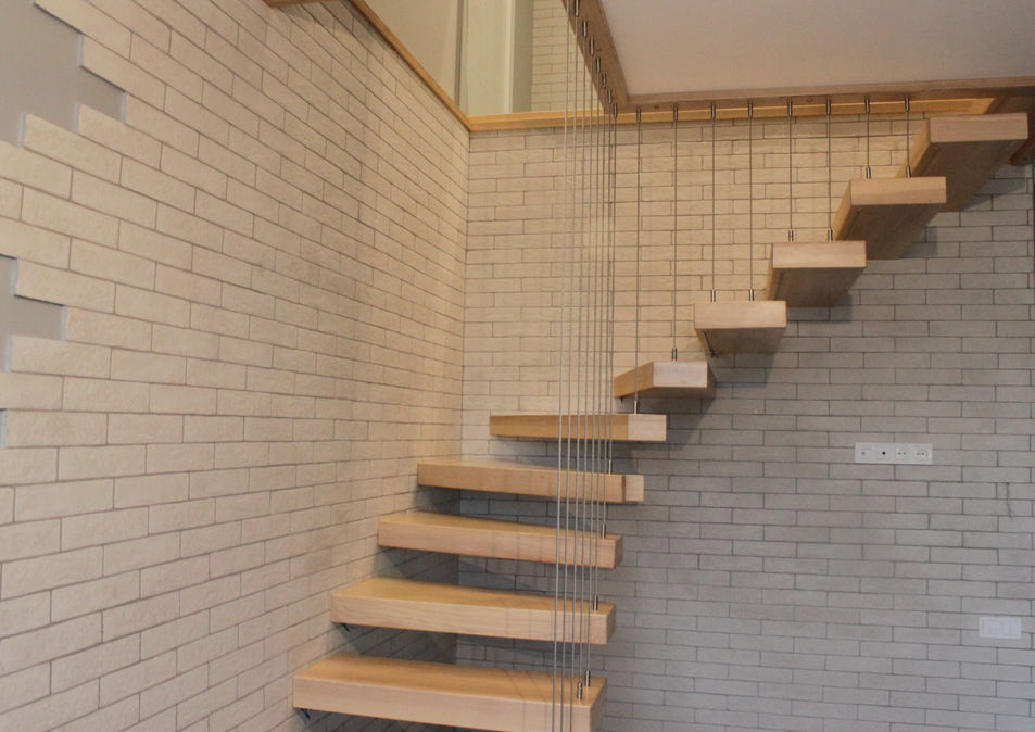 Консольні сходи з масиву ясена вздовж цегляної стіни