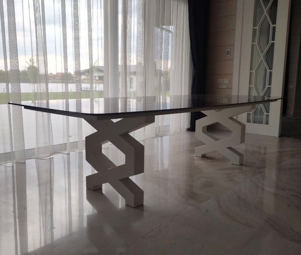 Біла металева ніжка столу складної геометричної форми.