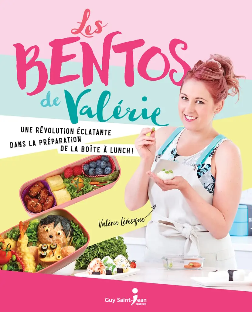 Couverture du livre "Les bentos de Valérie" par Valérie Lévesque. L'image montre une personne tenant une boule de riz, avec deux boîtes à bento remplies de divers aliments tels que des myrtilles, des boulettes de viande, des légumes et des sushis. Le texte sur la couverture lit :  "Les bentos de Valérie"  "Une révolution éclatante dans la préparation de la boîte à lunch!"  "Valérie Lévesque"  "Guy Saint-Jean Éditeur"