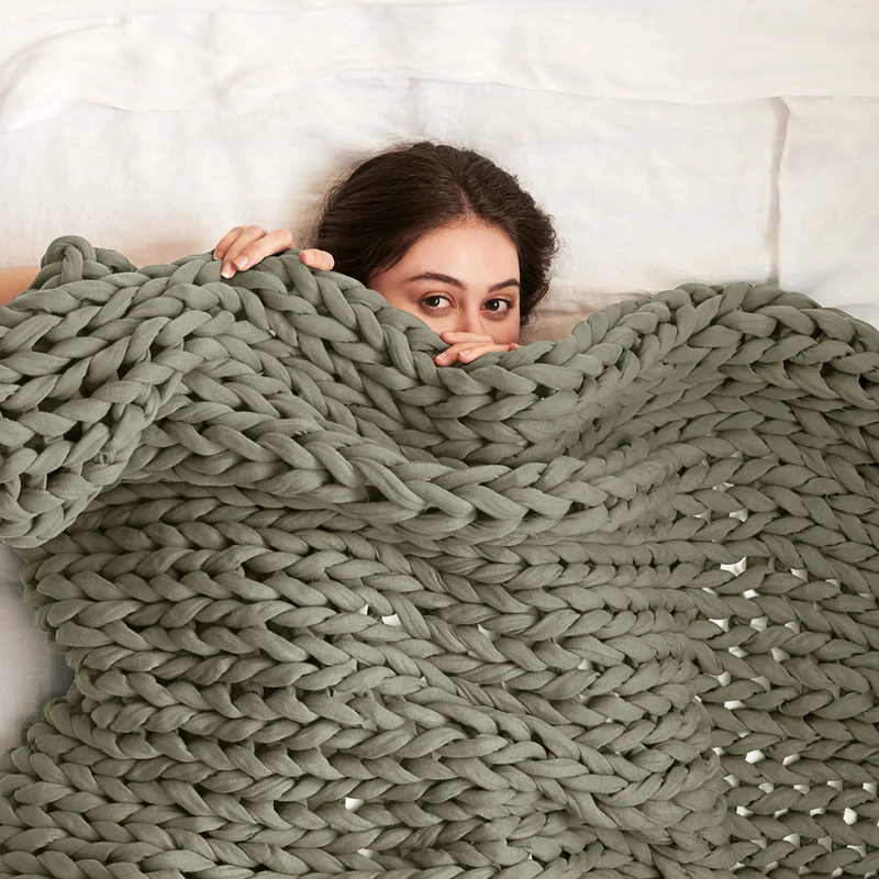A woman under a Bearaby blanket