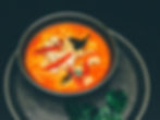 Thai red curry soup with peppers and chicken on top