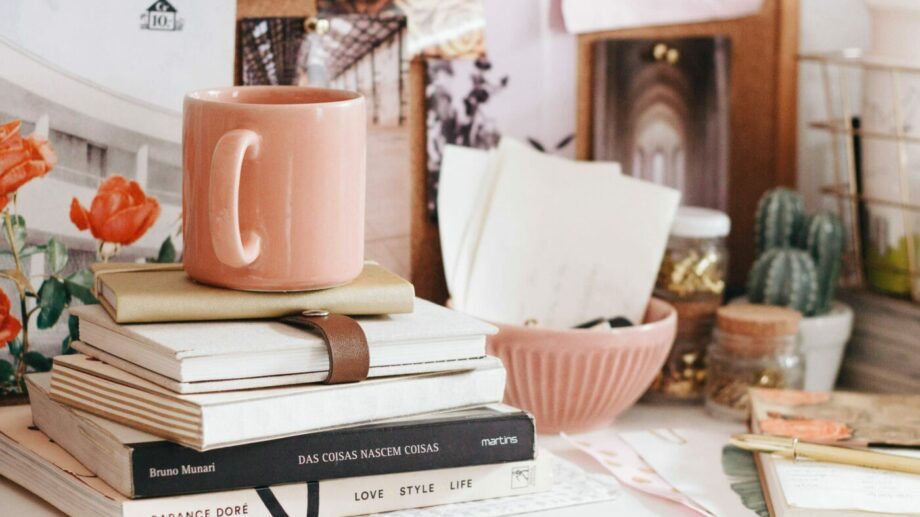 pink mug on stack of books and stationery - cotton on student discount