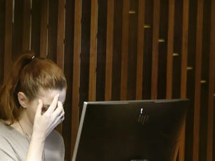 student in front of computer stressed and holding head