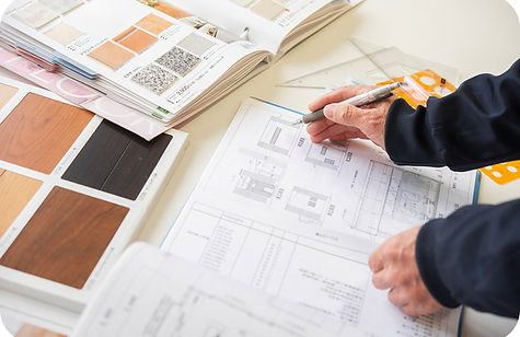 住宅の設計図を書き込みながら建材サンプルを確認する様子
