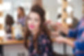 Female hairdresser standing and making hairstyle to cute lovely young woman in beauty salo