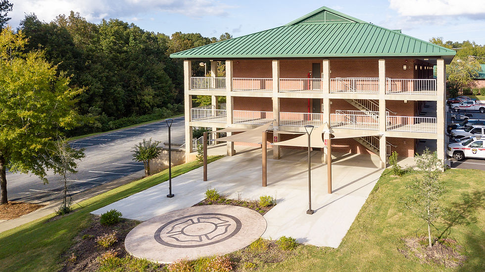 exterior image of building showing courtyard and three story building with full-length breezeways on each floor