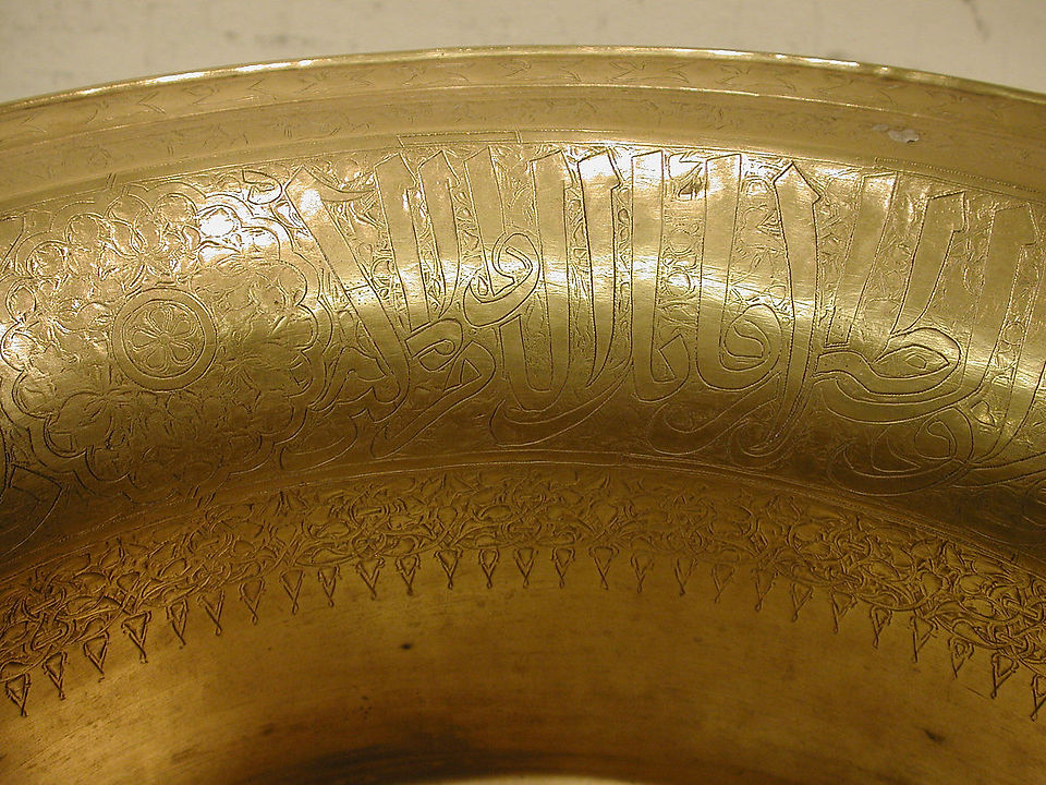 1321-1363. Attributed to Egypt or Syria. Brass; engraved and inlaid with silver and black compound. Interior inscription in Arabic: Glory to our Master, the Sultan, the King al-Mujahid, the Wise, the Ruler, the Mighty, the Victorious, the Conqueror, the Chief of the Kings and of the Sultans, the Killer of Unbelievers and Idolators, the Maker of Widows, the Sword of Islam, `Ali, the Chief of the Believers. Outside inscription in Arabic: Glory to our Master, the Sultan, the King al-Mujahid, the Wise, the Ruler, the Mighty, the Victorious, the Conqueror, the Sword of Islam, `Ali. May his victory be glorified. H. 8 1/2 in. (21.6 cm) Top Diam. 18 3/8 in. (46.5 cm). Accession no.: 91.1.589.