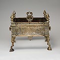 Second half of 13th Century. Egypt. Made for Rasulid Sultan al-Malik al-Muzaffar Shams al-Din Yusuf ibn 'Umar. Brass; cast, chased, inlaid with silver and black compound. Inscription on body in Arabic naskhi script: Glory to our lord the Sultan, the wise, the ruler, the just, the defender [of the faith], the warrior [at the frontiers], the supported [by God], the victorious, sultan of Islam and the Muslims, the subduer of insurgents and rebels, the Sultan al-Malik al Muzaffar Yusuf son of ‘Umar. Illegible inscription on legs in Kufic script. H. 13 7/8 in. (35.2 cm) W. 15 1/2 in. (39.4 cm) Max D. 16 3/8 in. (41.6 cm). Accession no.: 91.1.540.