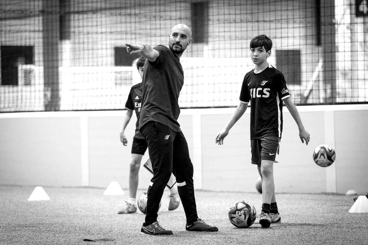 Coach Reinaldo Larotta teaching kids how to play soccer