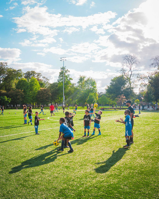 Coach Reinaldo Larotta teaching kids how to play soccer